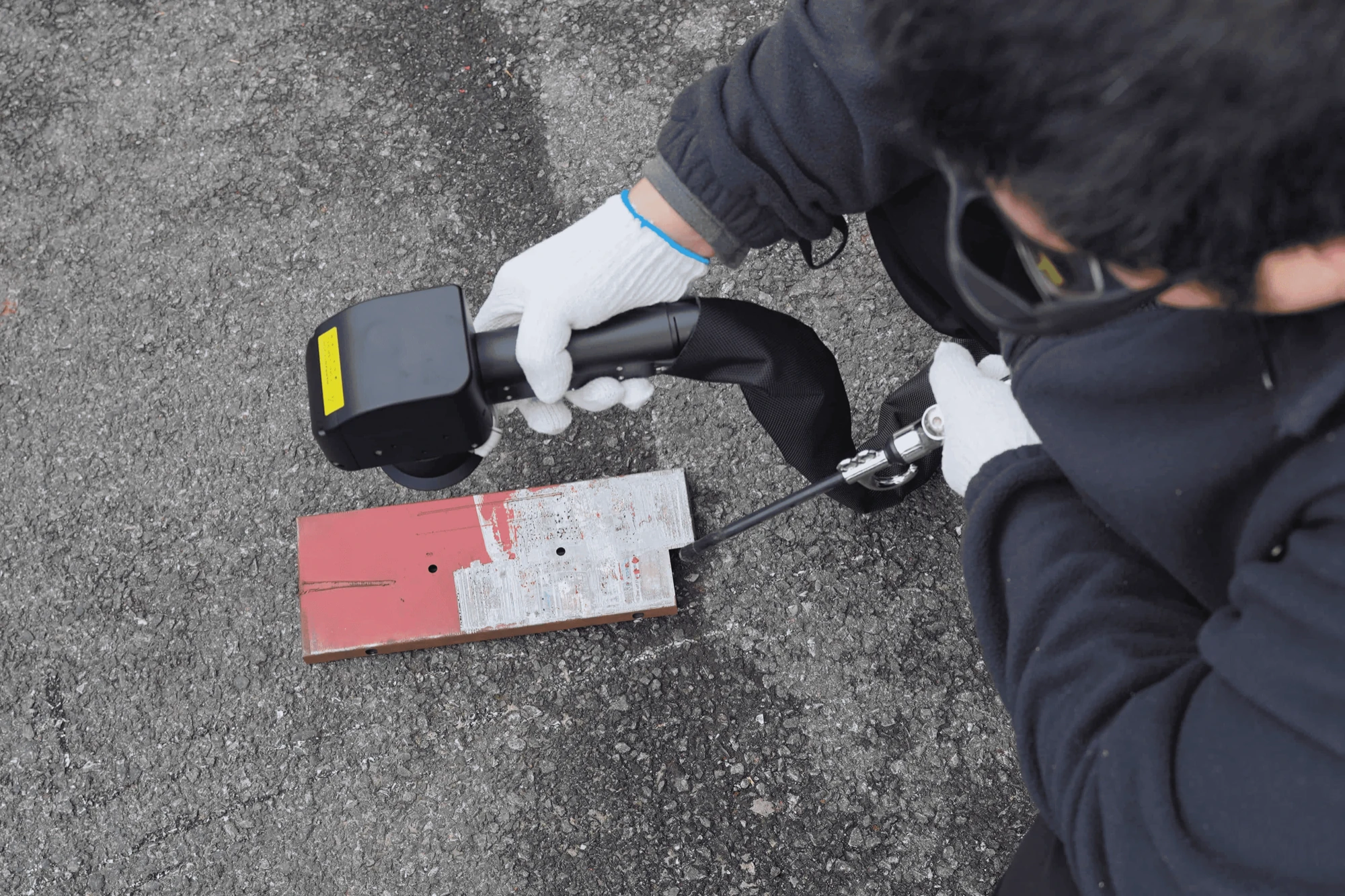 Close-up of a pulsed cleaning head removing coating from metal